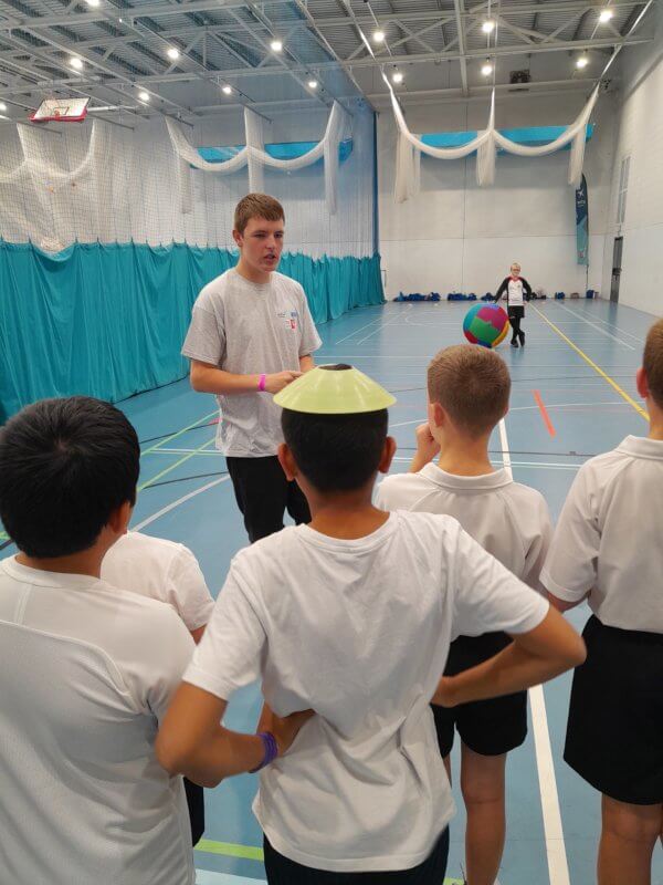 KS4 sports coaches explaining the game to pupils from local schools